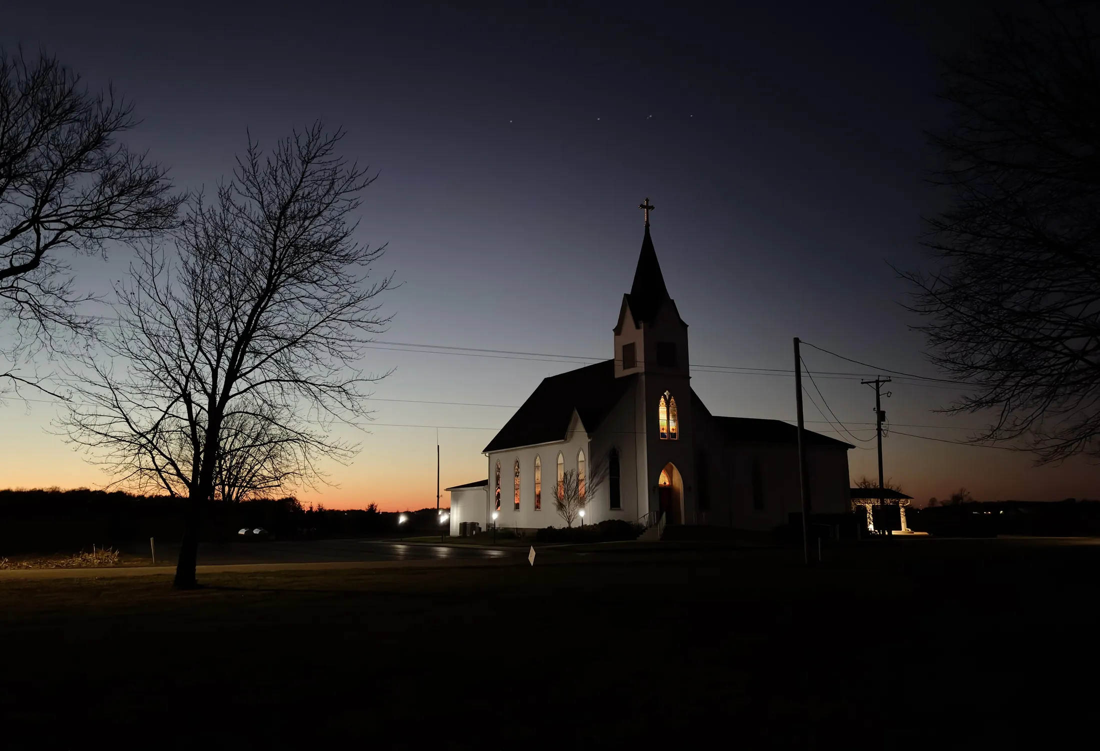 Immanuel Lutheran Church at evening, stained glass illuminated from within